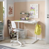 Arbeitsbereich für Kinder mit Schreibtisch, Stuhl, Regalen, Rucksack, Sportausrüstung, Motivationsposter.