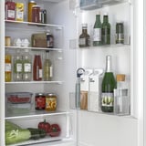 Organisierter Kühlschrank mit verstellbaren Regalen, durchsichtigen Fächern für Lebensmittel, Flaschen, Gläser und Produkte. LED-Beleuchtung beleuchtet alle Fächer.