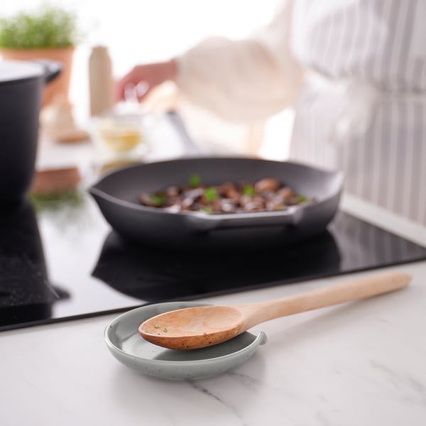 Küche mit Pfanne mit sautierten Pilzen, Löffelablage.