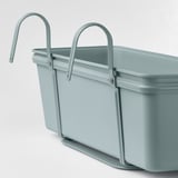 Ein hellblaues hängendes Pflanzgefäß mit verstellbaren Metallhaken, das für eine sichere Befestigung und ordnungsgemäße Entwässerung konzipiert ist.
