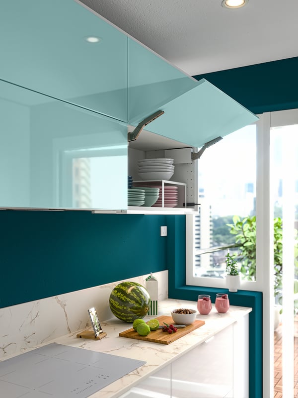 Moderne blaue Küche mit Marmor, offenem Regal und frischem Obst.