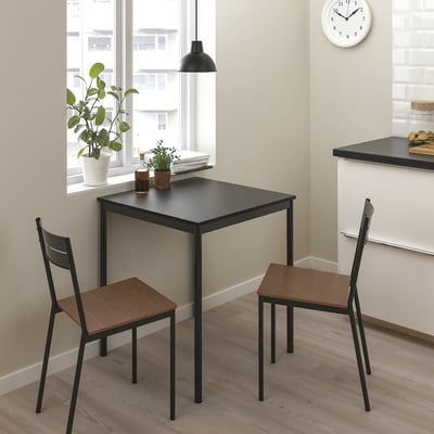 Kleine moderne Essgarnitur mit schwarzem Metallgestell und Holzsitzen. Perfekt für kompakte Räume.