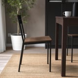 Stuhl mit Holzsitz und Metallbeinen; Teil der Sandberg-Serie, die für Komfort und kleinere Räume konzipiert wurde.