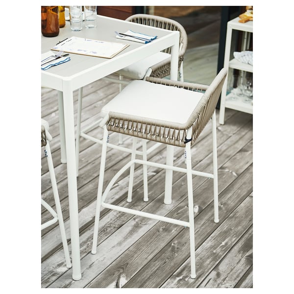 Moderner Outdoor-Stuhl: SEGERÖN in Weiß, Metallgestell & geflochtener Sitz, auf Holzdeck.