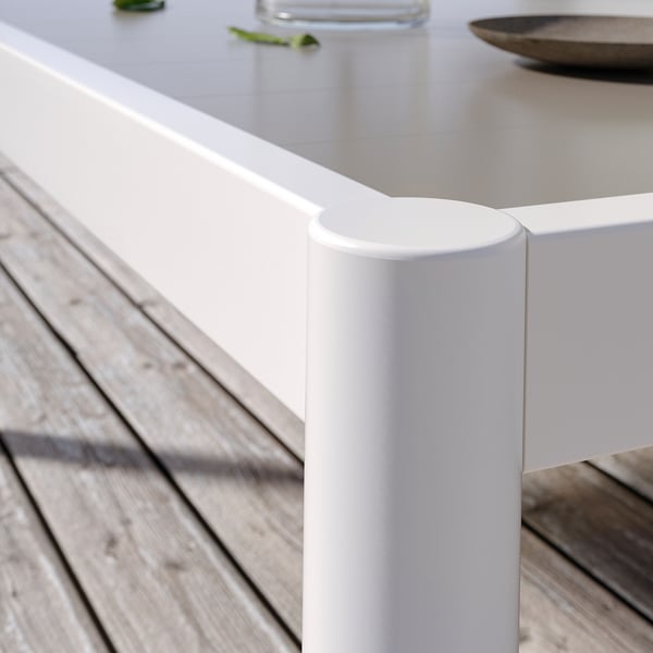 Ein weißer, moderner Outdoor-Tisch mit zylindrischen Beinen. Hergestellt aus Aluminium und pulverbeschichtetem Stahl, perfekt geeignet für Terrassen.