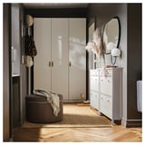 Moderner Eingangsbereich mit weißem Kleiderschrank, rundem braunem Hocker, weißem Schuhschrank, Spiegel und getrockneten Blumendekorationen.
