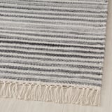 Grau-weißer handgewebter Wollteppich mit Fransen. Hochwertige, Textur und Handwerkskunst.