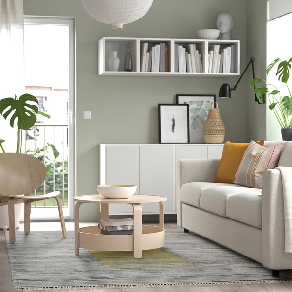 Gemütliches Wohnzimmer mit grauem SJÖTÅTEL-Teppich, Sofa, Pflanzen und Bildern.