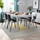 Modernes Esszimmer mit weißem Tisch, schwarzen Stühlen, gestreiftem Teppich, Essen und Pendelleuchten.