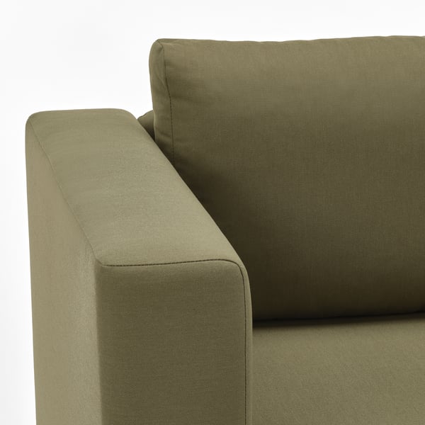 Olivgrünes Sofa aus nächster Nähe, das hochwertige Stoffe und Designdetails zeigt.