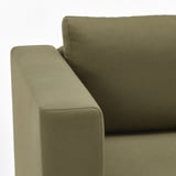 Olivgrünes Sofa aus nächster Nähe, das hochwertige Stoffe und Designdetails zeigt.