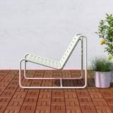 Ein schlanker, verstellbarer Outdoor-Sessel mit perforiertem Sitz auf einer Holzterrasse, der Komfort und einen modernen Look bietet.