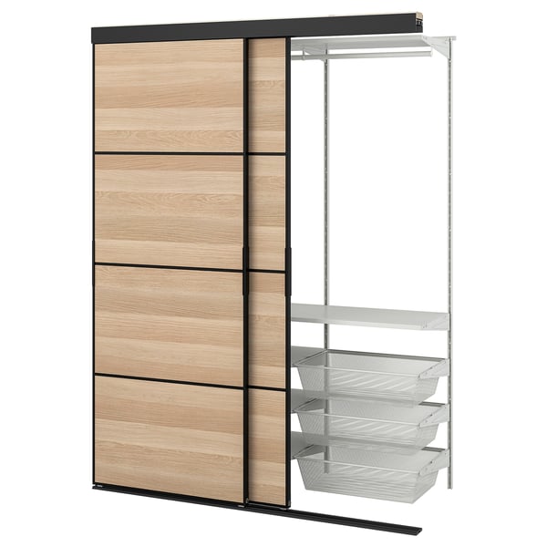Ein SKYTTA-Kleiderschrank aus Holz und Metall mit Schiebetüren und Drahtkörben. Es hat drei Fächer und eine Aufhängestange.
