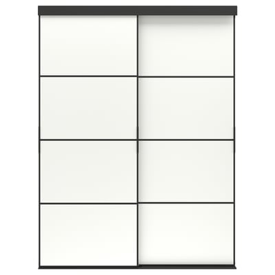 Zeigt einen SKYTTA-Kleiderschrank mit weißen Paneelen und schwarzen Akzenten. Es bietet Schiebetüren und bietet einen schlanken, modernen Look mit einer Garantie von zehn Jahren.