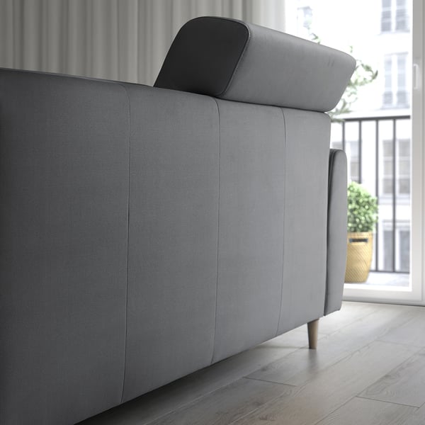 Graues Sofa mit verstellbarer Rückenlehne, hoher Rückenlehne, Fenster mit Blick auf die Stadt auf Holzboden.