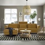 Modernes Wohnzimmer mit gelbem Sofa, gestreiftem Teppich und großen Fenstern.