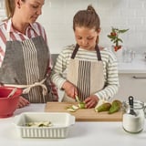 Kind und Erwachsener kochen gemeinsam in der Küche.