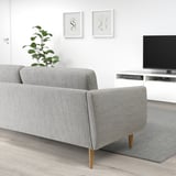 Modernes Wohnzimmer mit grauem SMEDSTORP-Sofa, Holzbeinen, Pflanze, TV und Kunst.