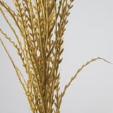 Nahaufnahme eines künstlichen Pflanzenstängels mit feinen, goldenen Blättern. Lebensechte Textur und Details, die das natürliche Laub perfekt nachahmen.