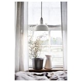 Fenster mit einer Hängelampe, einer Topfpflanze und einer weißen Vase auf dem Fensterbrett, die auch als Krug verwendet wird.