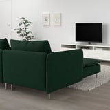 Modernes Wohnzimmer mit dunkelgrünem SÖDERHAMN-Sofa, TV, Pflanze und minimalistischer Kunst.