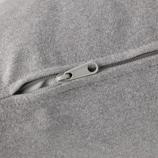 Nahaufnahme des Reißverschlusses auf einem gut gemachten, grau gepolsterten Sofa.