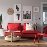 Rotes SÖDERHAMN Sektionssofa mit Kissen, beigem Teppich, Galeriewand, Couchtisch mit Becher und Schüssel.