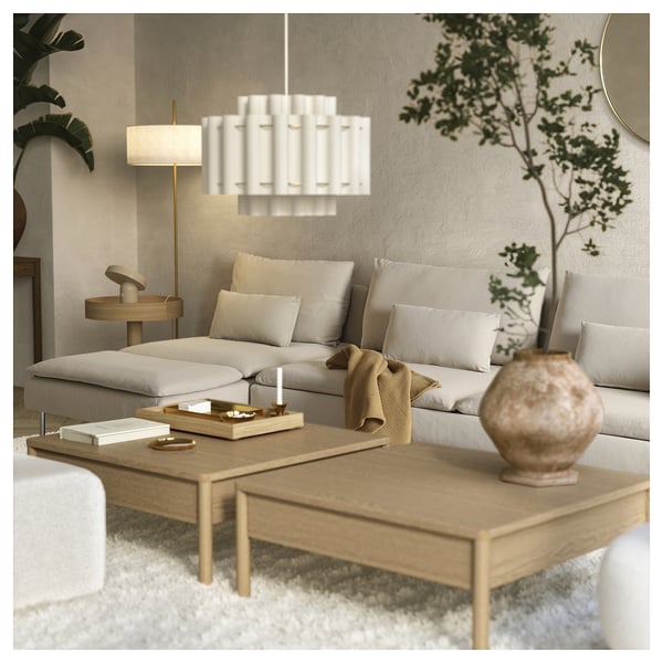 Modernes Wohnzimmer mit SÖDERHAMN beigem Sofa, hölzernem Couchtisch, weißem Kronleuchter und grünen Pflanzen.