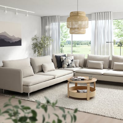 Modernes Wohnzimmer mit beigem Sofa, Couchtisch, großem Fenster mit durchsichtigen Vorhängen und Pendelleuchte.