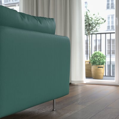 Modernes grünes Sofa in der Nähe eines großen Fensters mit Pflanzen.