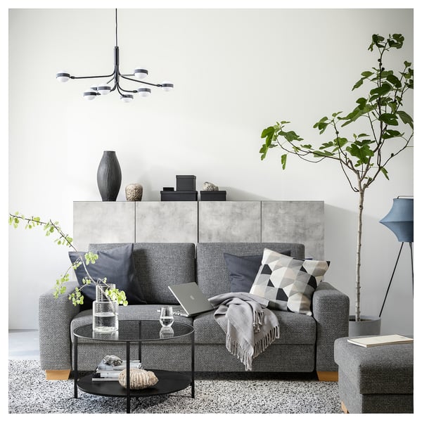 Modernes graues SÖRVALLEN-Sofa mit minimalistischem Design, Holzbeinen, Kissen und Zimmerpflanzen.