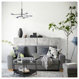 Modernes graues SÖRVALLEN-Sofa mit minimalistischem Design, Holzbeinen, Kissen und Zimmerpflanzen.