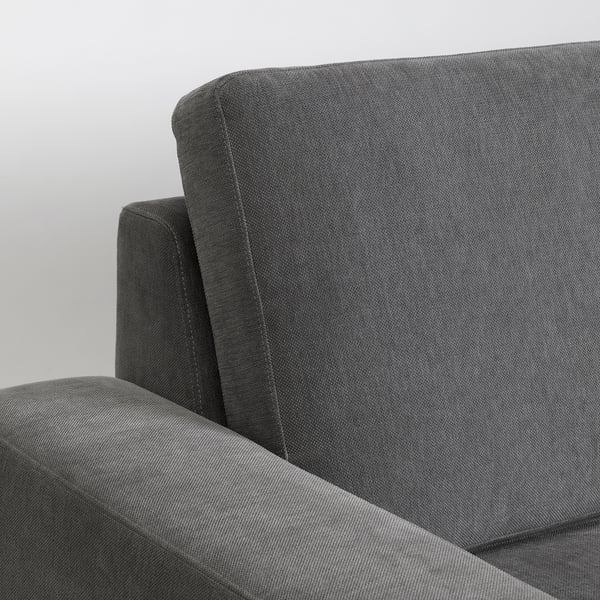 Nahaufnahme moderner grauer Sofas mit gepolsterter Rückenlehne und Armlehne, die hochwertige Stoffe und minimalistisches Design präsentieren.