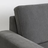Nahaufnahme moderner grauer Sofas mit gepolsterter Rückenlehne und Armlehne, die hochwertige Stoffe und minimalistisches Design präsentieren.