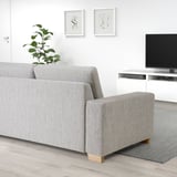 Modernes Wohnzimmer mit hellgrauer SÖRVALLEN-Couch, minimalistischer Einrichtung und TV.