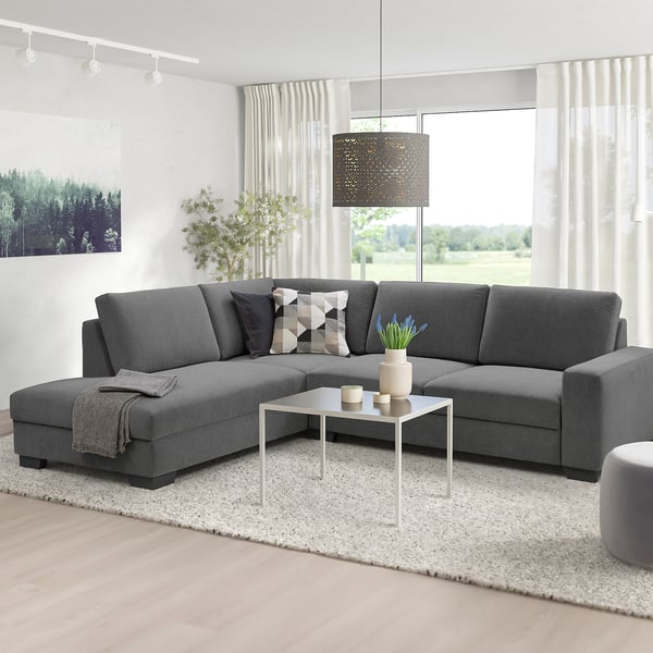 Modernes Wohnzimmer mit grauem SÖRVALLEN-Sektionssofa, minimalistisches Design. Großes, bequemes Stück mit niedriger Rückenlehne, geeignet für geräumige Räume.