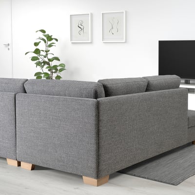 Modernes Wohnzimmer mit SÖRVALLEN Sofa, Pflanze, TV und Kunstwerken.
