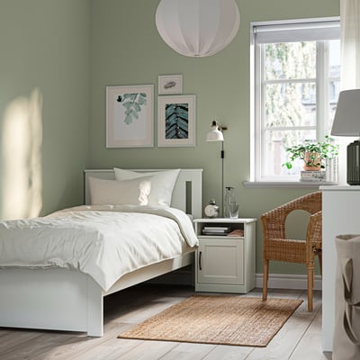 Weißer SONGESAND Bettrahmen mit hohen Beinen, weichen Kanten und klassischem Design.