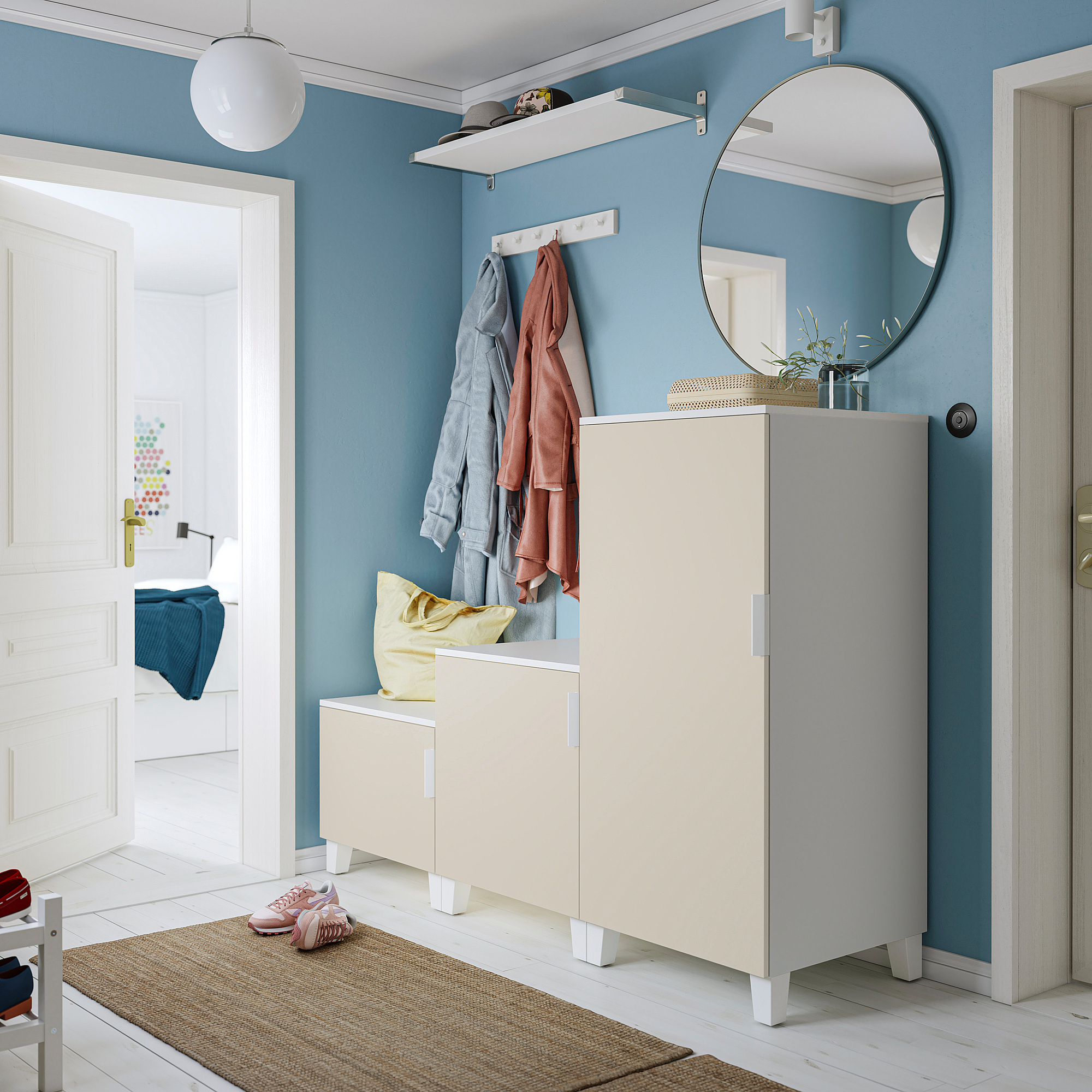 Moderner Eingangsbereich: blaue Wände, weiße Möbel, runder Spiegel, Schrank mit Spiegelplatte und gelbem Kissen.