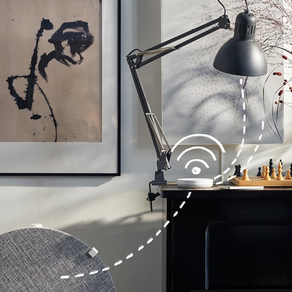 Moderner Schreibtisch mit Luftreiniger, Lampe und abstrakter Kunst.