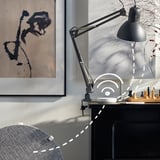 Moderner Schreibtisch mit Luftreiniger, Lampe und abstrakter Kunst.