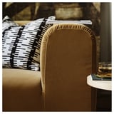 Elegantes Sofa mit braunem Samt, Plüschkissen und schwarz-weißen Kissen, das zum Entspannen einlädt.