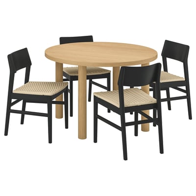 Moderne Essgarnitur mit rundem, wabengefülltem Tisch aus Eichenfurnier und vier schwarzen Stühlen mit Korbsitz, ideal für gemütliche Zusammenkünfte.