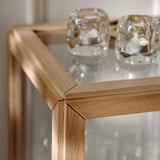 Nahaufnahme einer Glasvitrine mit Eichenrahmen, die feine Handwerkskunst und robuste Verbindungen zeigt.