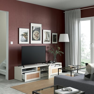 Modernes Wohnzimmer mit einem STUDSVIKENs-TV-Ständer mit geflochtenen Pappelschubladen mit einem Flachbild-TV, gerahmten Bildern und einer Lampe.