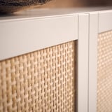 Geflochtener Holzschrank mit weißem Rahmen; Natürlicher, warmer Look.