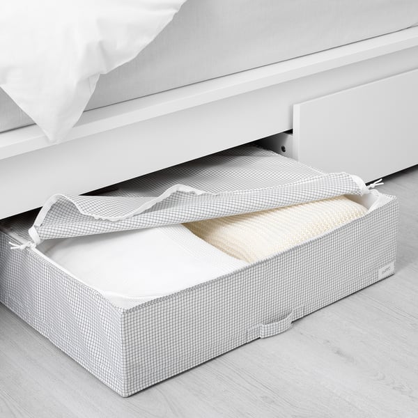 Aufbewahrungsbox unter dem Bett, Schutzdeckel offen, gefaltete Bettwäsche freigebend, Griffe für einfachen Zugriff.