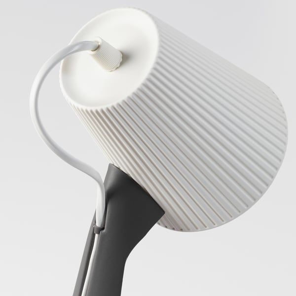 Weiße moderne Lampe mit geriffeltem Schirm, grauem Sockel und flexiblem Hals. Elegantes und funktionales Design.
