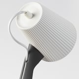 Weiße moderne Lampe mit geriffeltem Schirm, grauem Sockel und flexiblem Hals. Elegantes und funktionales Design.