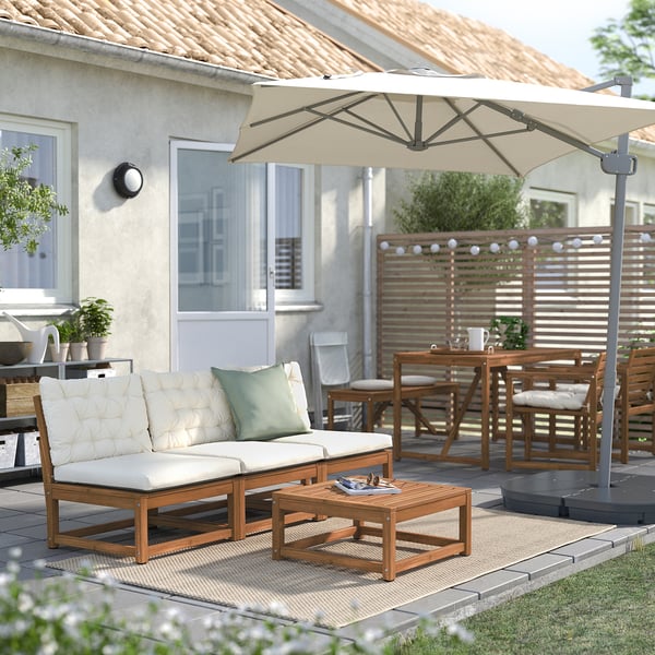 Gemütliche Außenterrasse mit Holzcouch, Couchtisch und beigem Sonnenschirm.